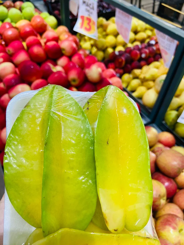 Carambolas frescas com maçãs ao fundo